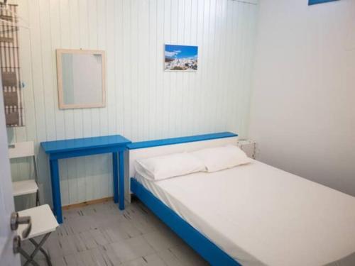 a bed with a blue table in a room at Amorgos Azur apartment in Tholária