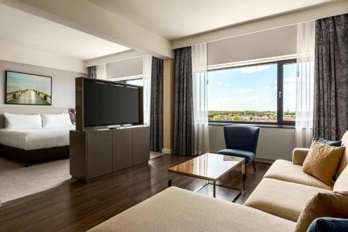 une chambre d'hôtel avec une télévision et un lit dans l'établissement Marriott Hotel The Hague, à La Haye