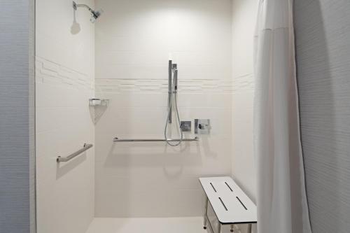 a white bathroom with a shower and a sink at Residence Inn by Marriott Valencia in Valencia