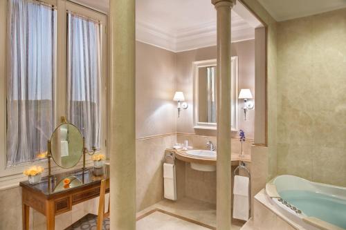 فندق روما ماريوت غراند فلورا في روما: حمام مع حوض ومغسلة ومرآة