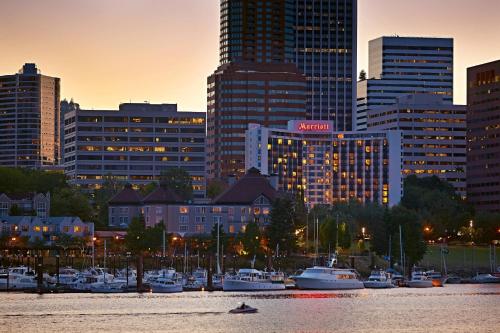 a city skyline with boats in a harbor at sunset at Portland Marriott Downtown Waterfront in Portland