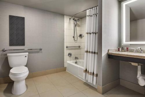 a bathroom with a toilet and a tub and a sink at Portland Marriott Downtown Waterfront in Portland