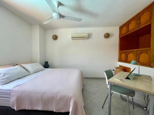 1 dormitorio con 1 cama y escritorio con ordenador portátil en A pasos de la playa! Acogedor apartamento en Bello Horizonte con Balcón I WiFi, en Playa Dormida