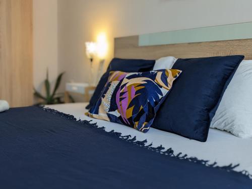 een bed met blauwe en witte lakens en kussens bij Zara Green Apartment 4 Guests Pet Friendly in Stara Zagora