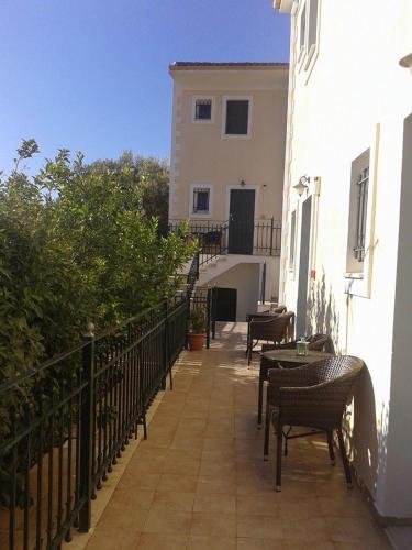 a balcony with chairs and tables and a building at Iriana Village Inn in Stavros