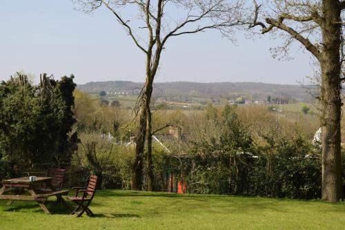 a picnic table and bench in a field of grass at Oakside Lodge Guest House in Canterbury