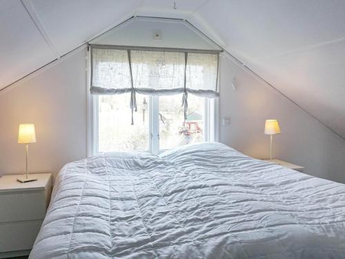sypialnia z dużym białym łóżkiem i oknem w obiekcie Holiday home Fjällbacka IV w mieście Fjällbacka