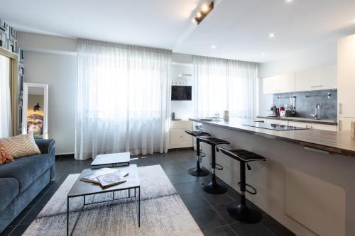 a living room with a couch and a kitchen at HIGHLAND Annecy Rent Lodge in Annecy