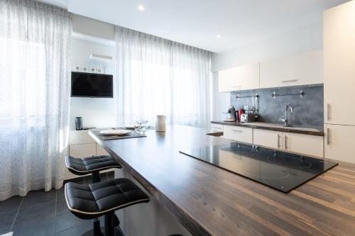 a kitchen with a large wooden counter with two bar stools at HIGHLAND Annecy Rent Lodge in Annecy