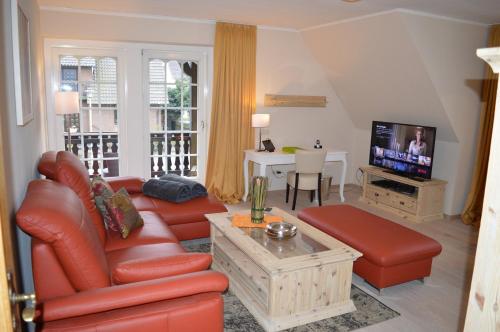 a living room with a couch and a tv at Landhaus Zum Heidewanderer mit THERMEplus in Bad Bevensen