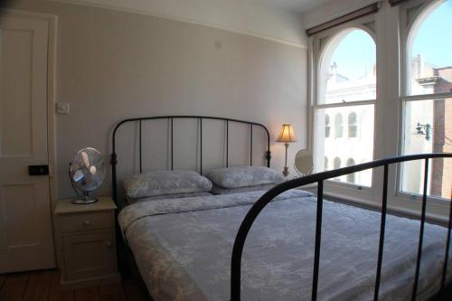 a bedroom with a bed and a large window at 2 Bedroom Boutique Maisonette on Kings Road, St Leonards on Sea in St. Leonards