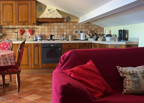 a living room with a red couch in front of a kitchen at SEA VIEW Apartment in Giardini Naxos