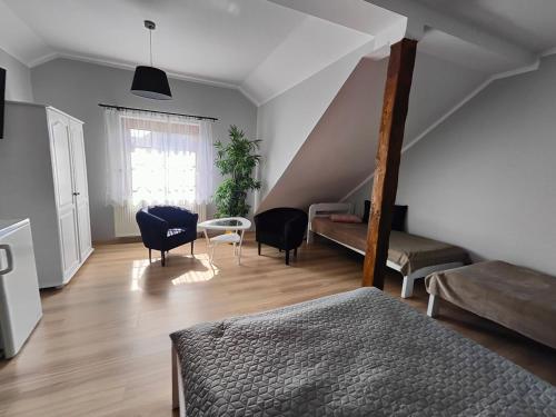 um quarto com uma cama e cadeiras e uma escada em Pokoje gościnne u Izy em Tolkmicko
