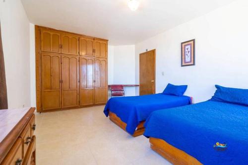 a bedroom with two beds and a wooden cabinet at InTown Beach front condo - Casey`s condo 1 in San Felipe