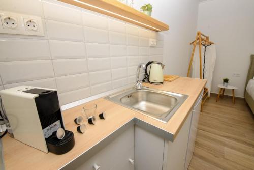 a small kitchen with a sink and a microwave at Kumquat studio Gouvia in Gouvia