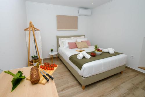 Un dormitorio con una cama y una mesa con comida. en Kumquat studio Gouvia en Gouvia