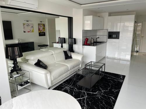 un salon avec un canapé blanc et une table dans l'établissement Ibis croisette, à Cannes