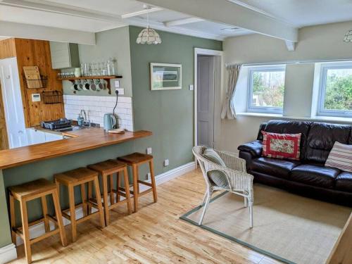 a kitchen and a living room with a couch at Cosy Cottage Crundale 