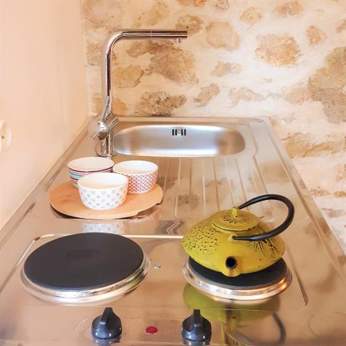 um balcão de cozinha com um lavatório com tigelas e um bule de chá em Little house with a large roof garden in the city center em Marselha