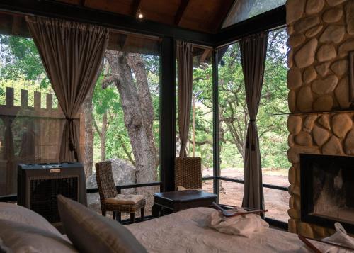 a bedroom with a bed and a large window at Cabañas Cascada del Barro in Guajuquito