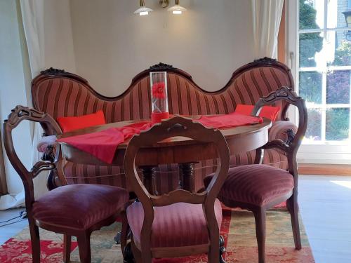 a wooden table with chairs and a table with red pillows at Landhaus Zum Heidewanderer mit THERMEplus in Bad Bevensen