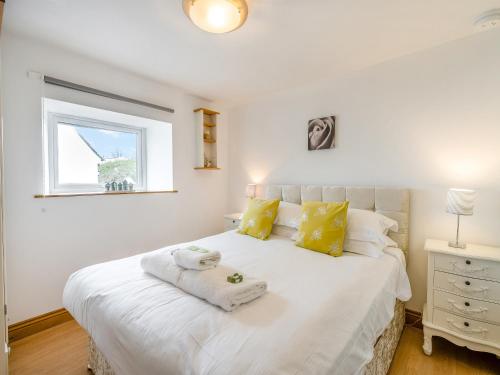a bedroom with a white bed with towels on it at Ben Ma Cree in Portpatrick