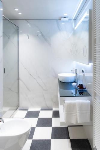 a bathroom with a sink and a tub and a toilet at Palazzo Scappi Gardi Luxury Apartments in Bologna
