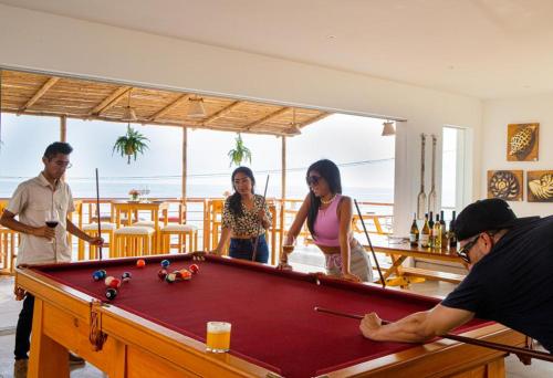 a group of people standing around a pool table at Casablanca del Mar in Punta Hermosa