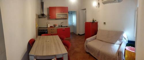 a small kitchen with a wooden table and a couch at Casa dell'Arco Civico 35 in San Fruttuoso