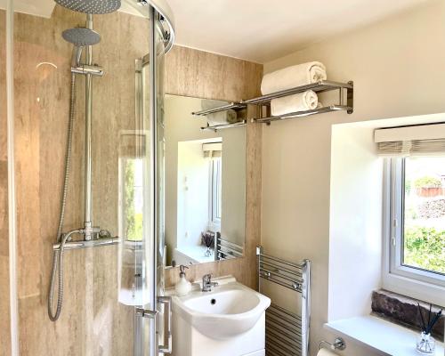 ein Bad mit einem Waschbecken und einer Dusche in der Unterkunft Hideaway Cottage in Barnoldswick