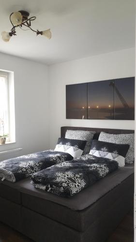 1 dormitorio con 1 cama con sábanas blancas y negras en SeenSucht & Urlaubsträume, Ferienwohnung "Seerose", en Großräschen