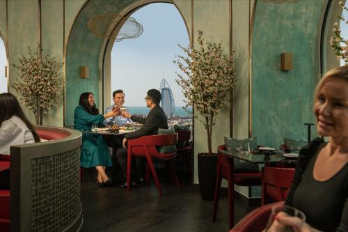 a group of people sitting at a table in a restaurant at Sheraton Mall of the Emirates Hotel, Dubai in Dubai