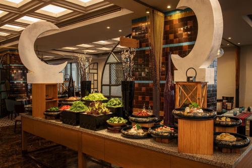 a buffet of food on a counter in a restaurant at Sheraton Mall of the Emirates Hotel, Dubai in Dubai