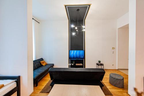 een woonkamer met een zwarte leren bank en een spiegel bij My city apartment-Vienna Familyroom in Wenen