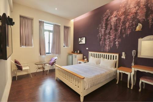 Schlafzimmer mit einem Bett mit Wandgemälde in der Unterkunft 好窩旅店 in Altstadt von Hengchun