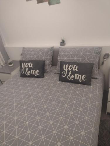 a bed with two pillows that say you be me at Mare kuća za odmor in Šibenik