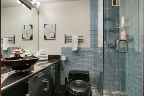 a bathroom with a sink and a glass shower at Stylish Studio with Full Kitchen & Modern Bathroom - Chestnut 15C in Chicago