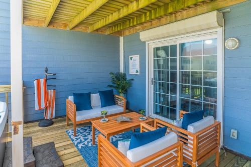 a porch with chairs and a table and a window at Hot Tub - Ocean Views - Steps to Private Beach - Quiet Location in Galveston