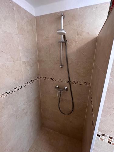 a shower with a shower head in a bathroom at Madonna Guest House in Dubrovnik