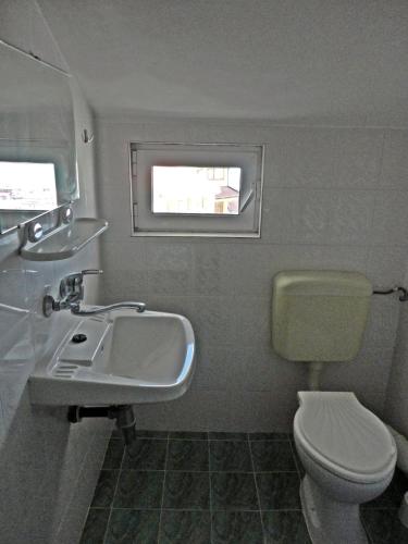 a bathroom with a sink and a toilet and a window at Guest Rooms Casa Luba in Sveti Vlas