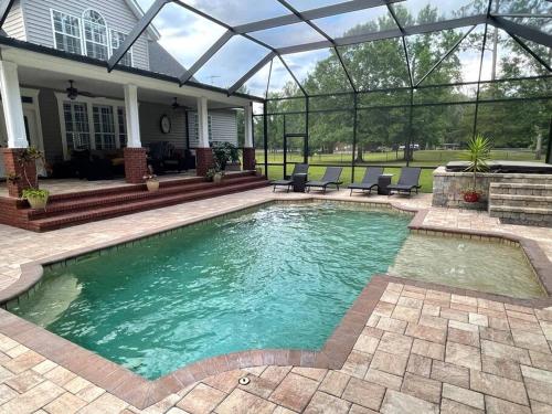 a swimming pool in the backyard of a house at Country Villa pool hot tub game room pond in Jacksonville