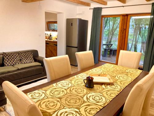 uma sala de jantar com mesa e cadeiras e uma cozinha em Hacienda Verde em Szentes