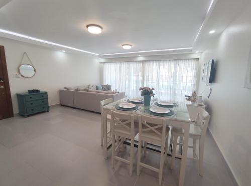 a dining room with a white table and chairs at Chic Beach Apartment - 3 min to the Beach in Punta Cana