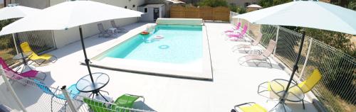 an overhead view of a swimming pool with chairs and umbrellas at Buddleia in Cherbonnières