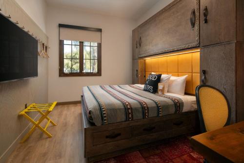 a bedroom with a bed with a wooden headboard at Moxy Santa Barbara in Santa Barbara