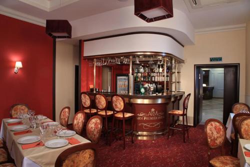 a restaurant with a table and chairs and a bar at Arm Premier Hotel in Cherepovets