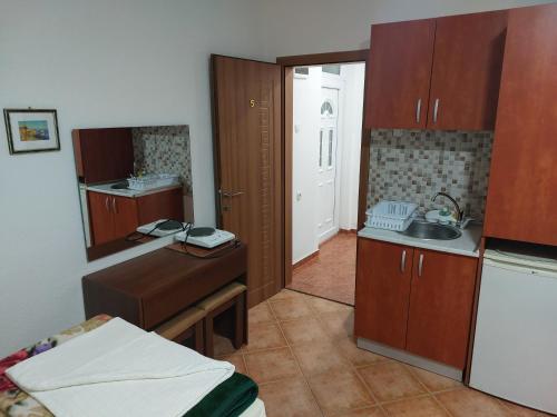 a small kitchen with wooden cabinets and a sink at Vila Marija - Teo in Star Dojran