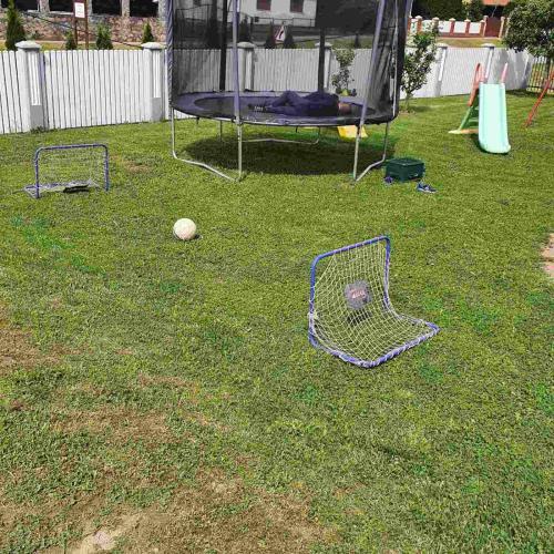 a playground with a net on the grass at Apartmani Apolon in Vrdnik