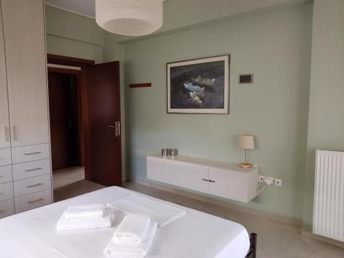 a bedroom with a bed with two towels on it at Villa Tsios in Artemida