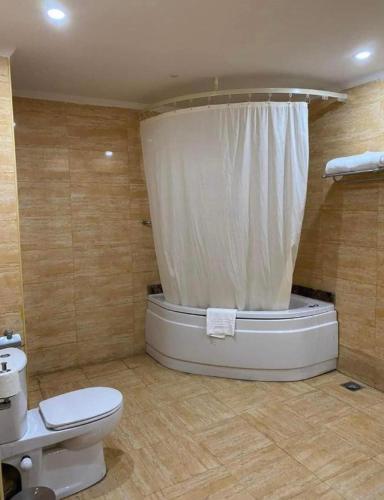 a bathroom with a toilet and a tub with a shower at Porto Marina Patio Suite - Egyptian Residents Only in El Alamein